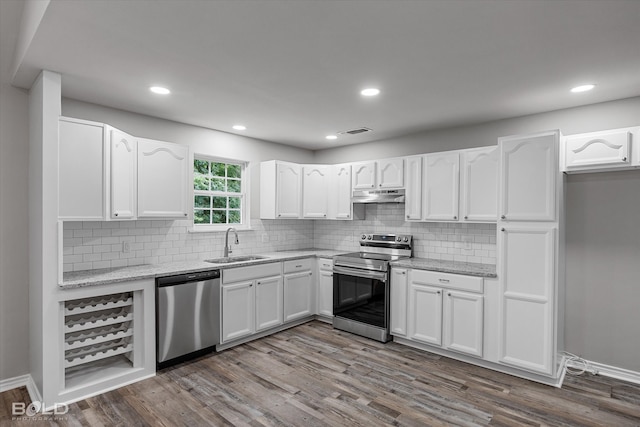 kitchen with dark hardwood / wood-style flooring, sink, appliances with stainless steel finishes, and white cabinetry