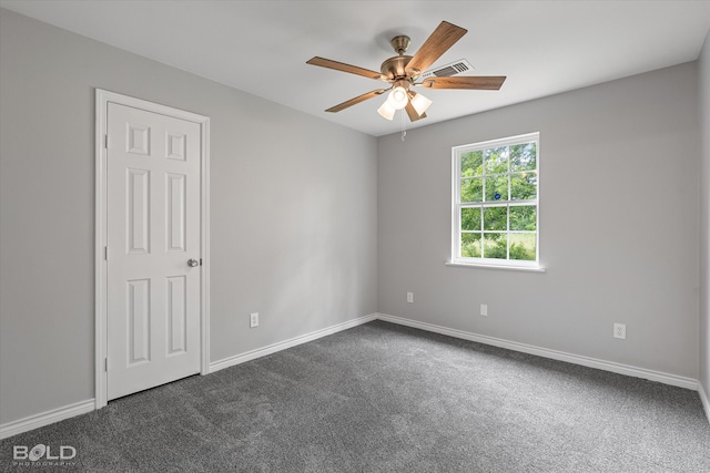 spare room featuring ceiling fan and dark colored carpet