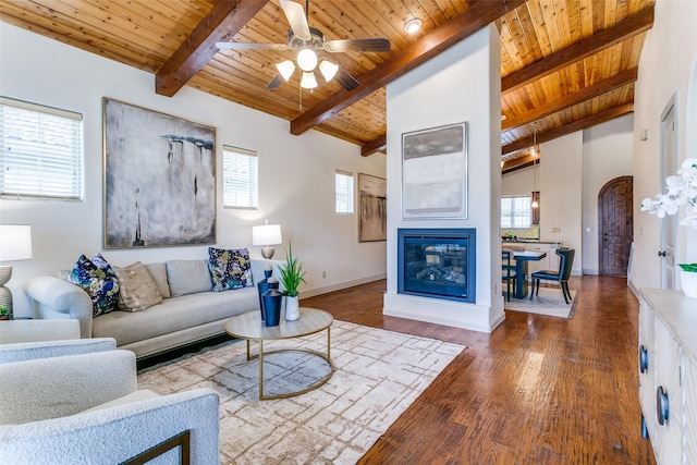 living room featuring hardwood / wood-style floors, vaulted ceiling with beams, ceiling fan, and wood ceiling