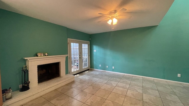 unfurnished living room featuring ceiling fan, light tile patterned floors, a fireplace, and french doors