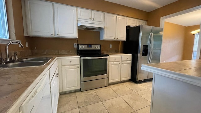 kitchen with light tile patterned flooring, sink, white cabinets, and stainless steel appliances