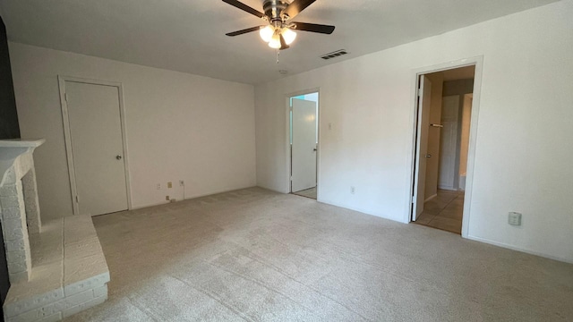 interior space with ceiling fan and a brick fireplace