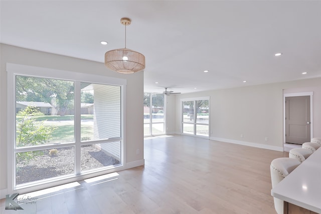 living room featuring light wood-type flooring, a wealth of natural light, and ceiling fan