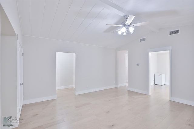 spare room featuring light wood-type flooring, ceiling fan, and vaulted ceiling with beams