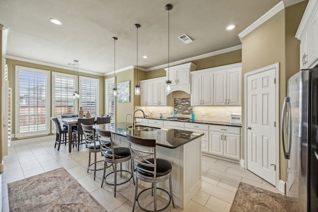 kitchen with white cabinets, appliances with stainless steel finishes, and pendant lighting