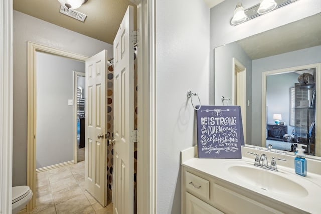 bathroom with tile patterned flooring, vanity, and toilet