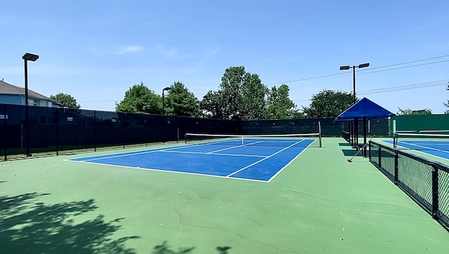 view of tennis court featuring basketball hoop