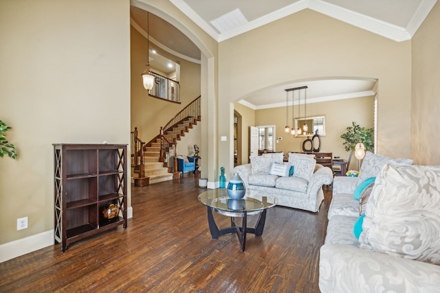 living room with dark hardwood / wood-style floors, lofted ceiling, ornamental molding, and an inviting chandelier