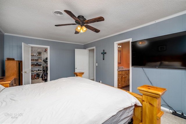 bedroom featuring ensuite bath, ceiling fan, a closet, and ornamental molding