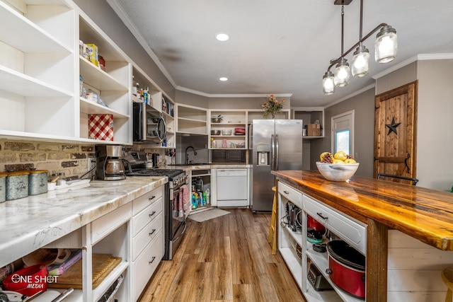 kitchen featuring wood counters, stainless steel appliances, pendant lighting, white cabinets, and light hardwood / wood-style floors