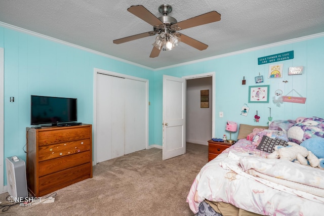 bedroom with ceiling fan, light colored carpet, a textured ceiling, a closet, and ornamental molding