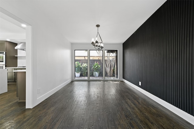 unfurnished dining area with dark wood-type flooring and a notable chandelier