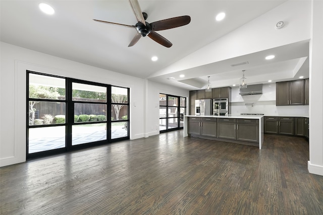 kitchen with a wealth of natural light, pendant lighting, an island with sink, and stainless steel appliances