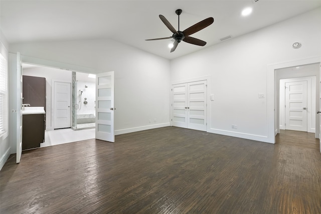 unfurnished living room featuring ceiling fan, dark hardwood / wood-style flooring, and vaulted ceiling