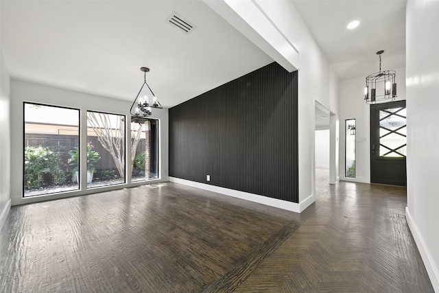 entrance foyer featuring dark hardwood / wood-style flooring and an inviting chandelier