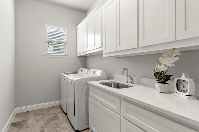 clothes washing area with washer and dryer, sink, and cabinets