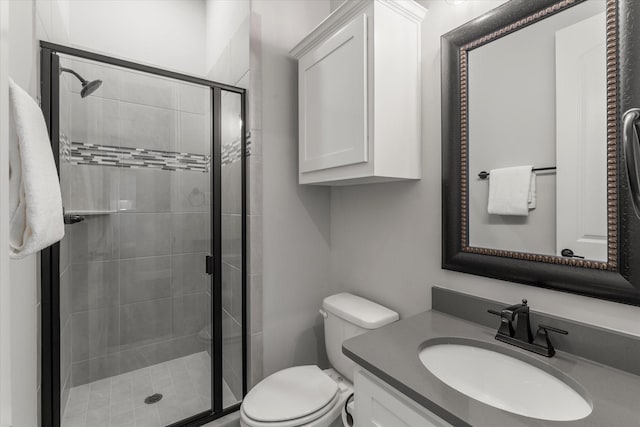 bathroom with a shower with door, vanity, and toilet