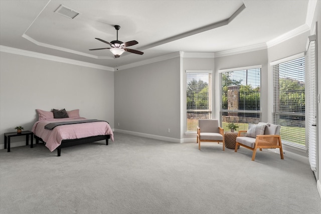 bedroom featuring ceiling fan, light colored carpet, ornamental molding, and a tray ceiling