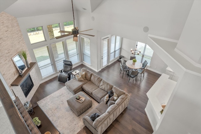 living room featuring ceiling fan with notable chandelier, dark hardwood / wood-style floors, and high vaulted ceiling