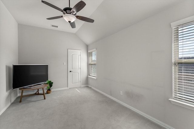 carpeted bedroom with ceiling fan, vaulted ceiling, and multiple windows