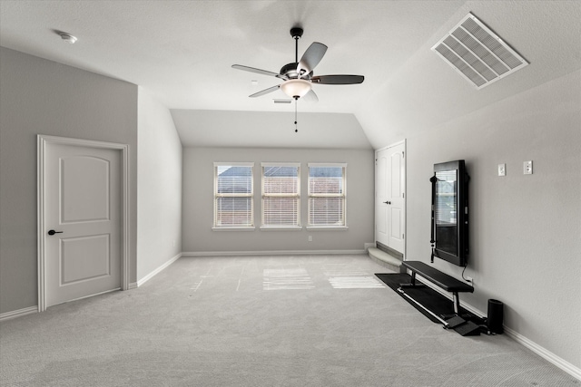 unfurnished living room with ceiling fan, lofted ceiling, and light carpet