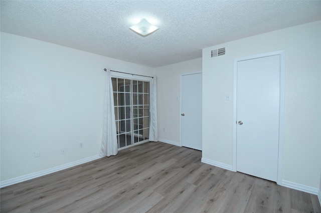 unfurnished bedroom with a textured ceiling and hardwood / wood-style flooring