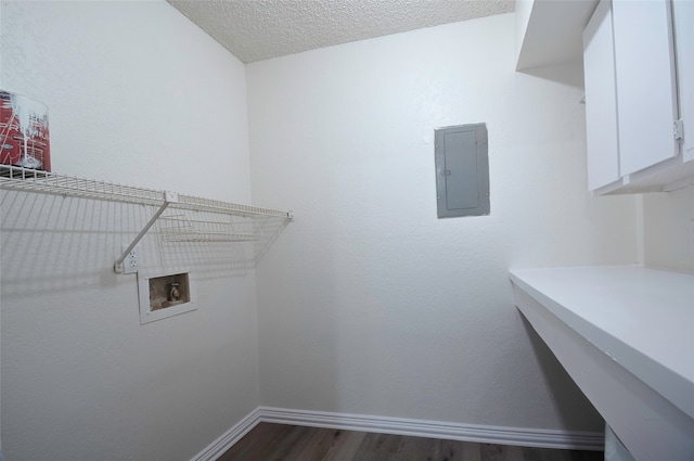 laundry room with wood-type flooring, electric panel, cabinets, hookup for a washing machine, and a textured ceiling