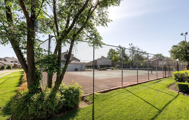 view of tennis court featuring a lawn