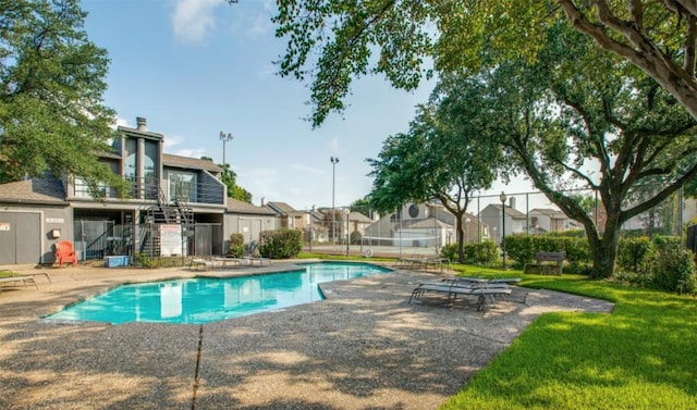 view of pool featuring a patio area and a yard