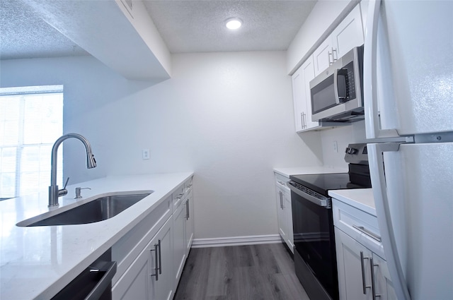 kitchen with white cabinets, sink, range with electric stovetop, dark hardwood / wood-style floors, and a textured ceiling