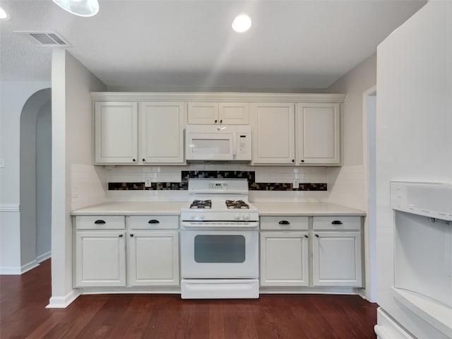 kitchen with backsplash, white cabinetry, dark hardwood / wood-style floors, and white appliances