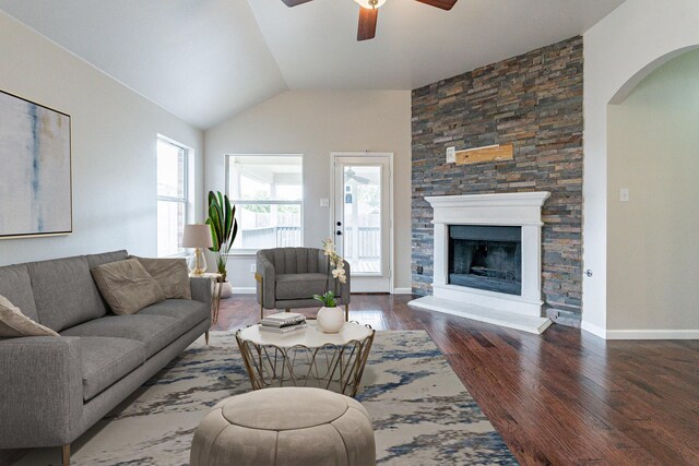 living room featuring lofted ceiling, ceiling fan, a fireplace, and dark hardwood / wood-style floors