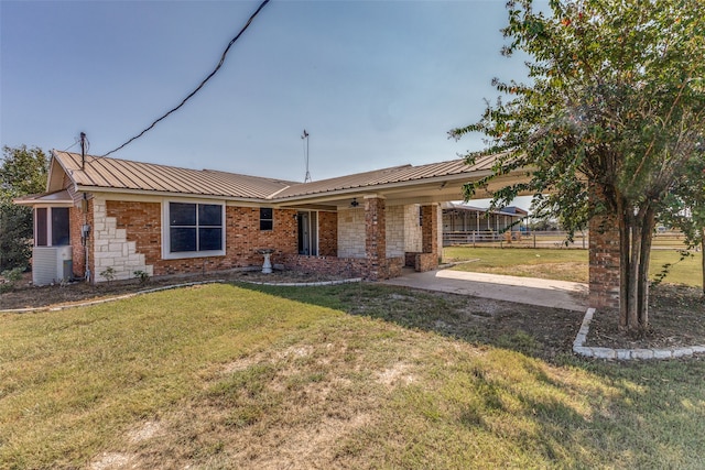 ranch-style house with cooling unit and a front lawn