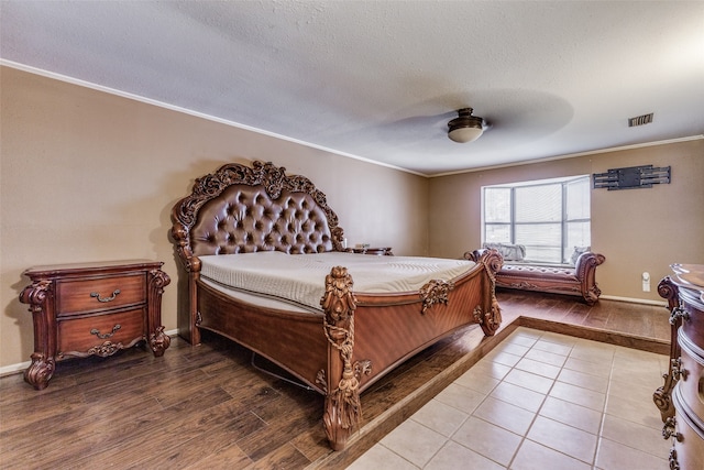 bedroom featuring a textured ceiling, crown molding, ceiling fan, and hardwood / wood-style flooring