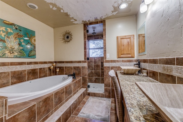 bathroom with tile walls, shower with separate bathtub, tile patterned floors, and vanity