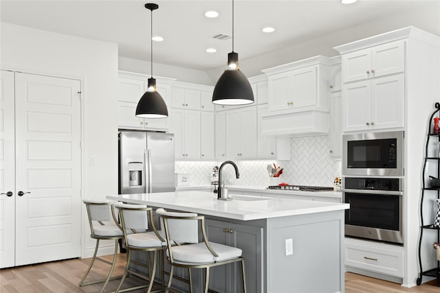 kitchen featuring a sink, light wood-type flooring, white cabinetry, and stainless steel appliances