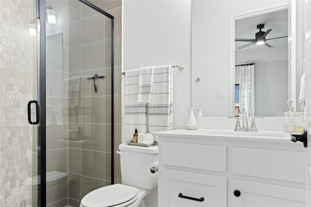 bathroom featuring vanity, toilet, a ceiling fan, and a stall shower