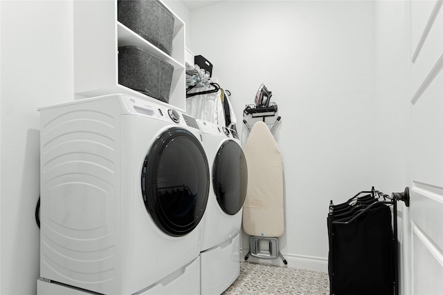 laundry area featuring laundry area, washing machine and dryer, and baseboards