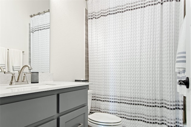 bathroom featuring curtained shower, toilet, and vanity