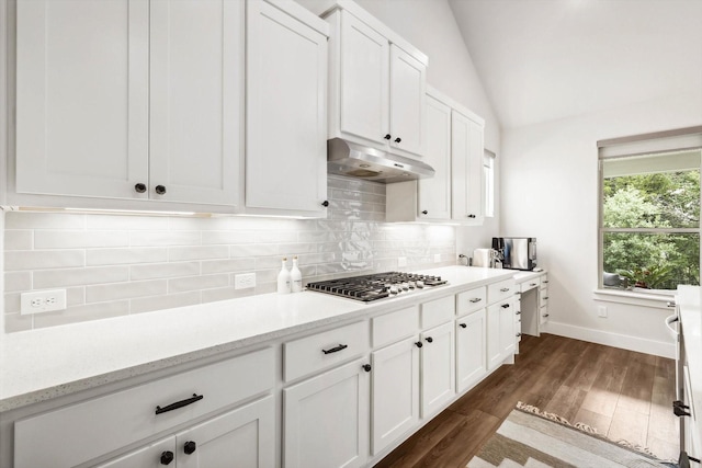 kitchen with stainless steel gas cooktop, white cabinetry, vaulted ceiling, dark hardwood / wood-style floors, and backsplash