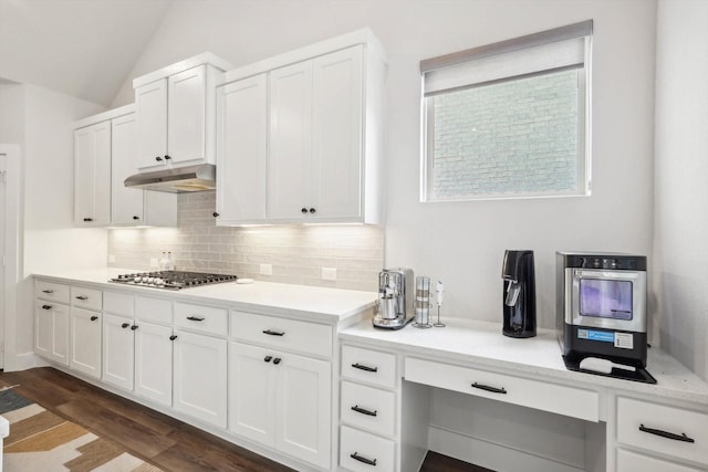 kitchen featuring vaulted ceiling, dark hardwood / wood-style floors, tasteful backsplash, white cabinets, and stainless steel gas cooktop