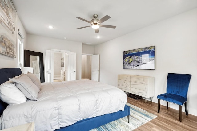 bedroom with connected bathroom, wood-type flooring, and ceiling fan