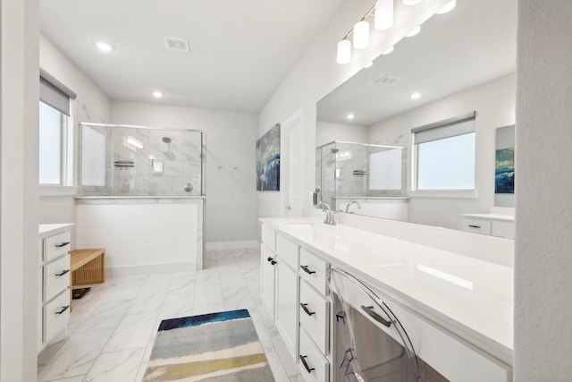 bathroom featuring vanity, a shower with door, and plenty of natural light