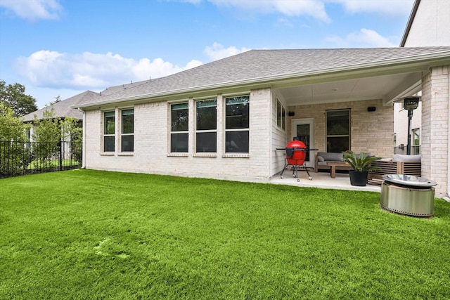 rear view of property featuring a yard, outdoor lounge area, and a patio