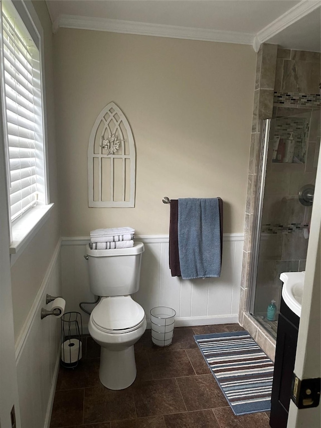 bathroom with vanity, crown molding, a shower with shower door, and toilet