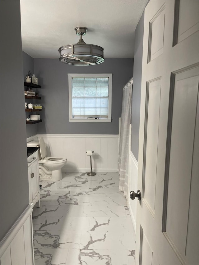 bathroom with vanity, curtained shower, and toilet