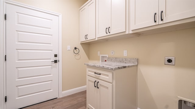 laundry room featuring washer hookup, cabinets, gas dryer hookup, light hardwood / wood-style flooring, and electric dryer hookup