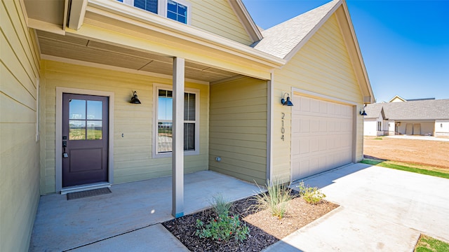 doorway to property with a porch and a garage