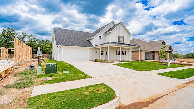 modern inspired farmhouse featuring a garage, a front yard, and a porch