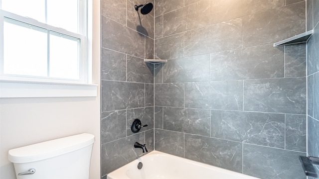 bathroom featuring tiled shower / bath combo and toilet